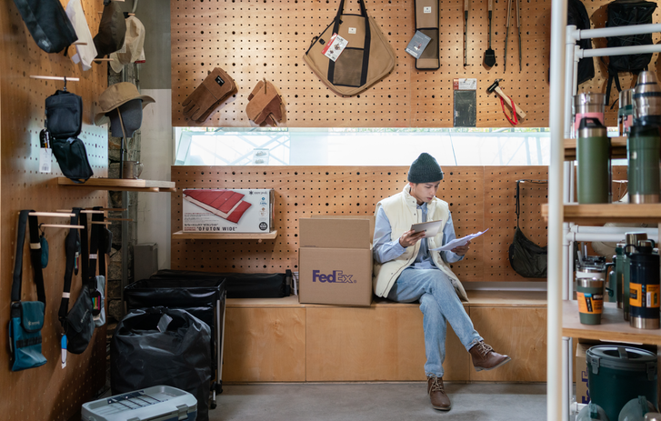 Uomo seduto accanto a una FedEx Box