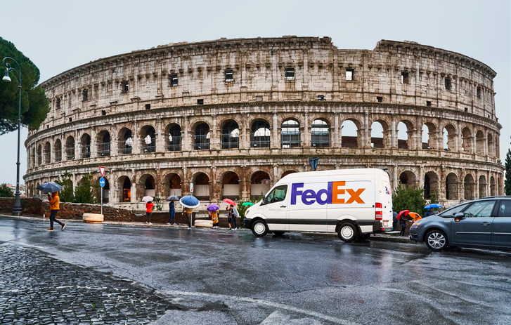 FedEx van driving in front of the Colosseum