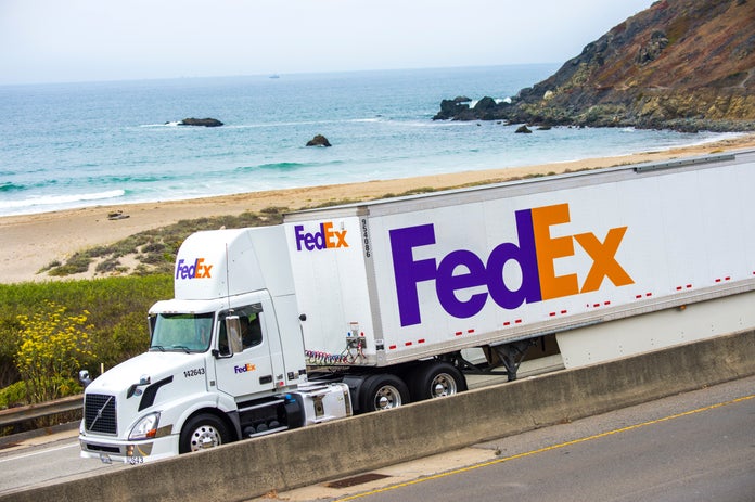 FedEx Ground truck driving on highway alongside the beach