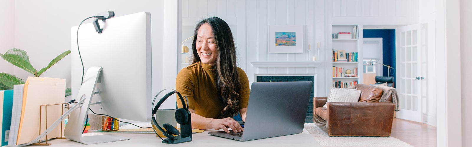 woman working on her laptop and looking at a desktop computer