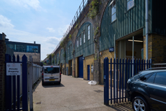 An estate, with multiple arches next to each other. The arches have closed electric roller shutter entrances.