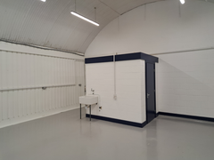 An empty arch with lining and a WC cubicle to the back