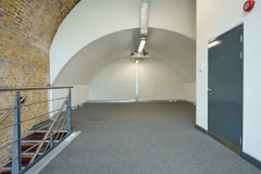 The mezzanine level of an arch, with carpet and lined white.