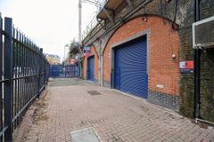 An estate, with multiple arches next to each other. The arches have closed electric roller shutter entrances.