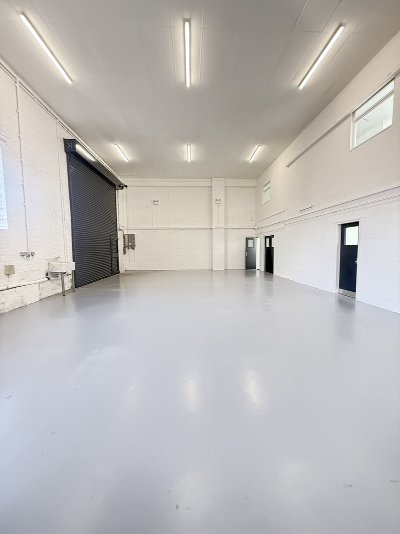 An empty arch with white lining and a WC cubicle to the back.