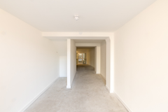 An empty arch with lining and full height glazing to the front