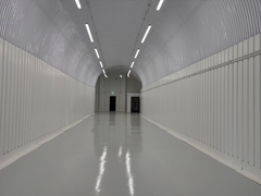 An empty arch with white lining and a WC cubicle to the back.