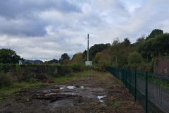 A large plot of land, with metal fencing around it.