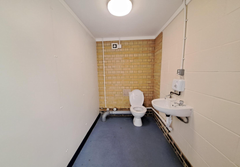 An empty arch with lining and a WC cubicle to the front
