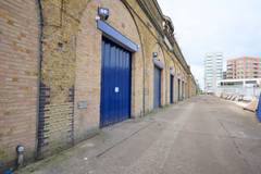 An estate, with multiple arches next to each other. The arches have closed electric roller shutter entrances.