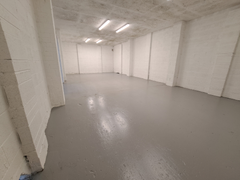 An empty arch with white lining and a WC cubicle to the front.