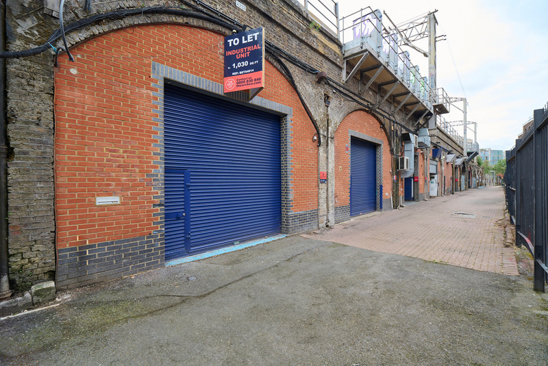 An estate, with multiple arches next to each other. The arches have closed electric roller shutter entrances.