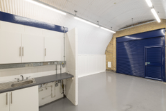 An empty arch with lining and a WC cubicle to the back