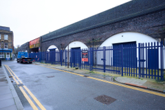 An estate, with multiple warehouse units next to each other. The arches have closed electric roller shutter entrances.
