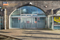 An empty arch with white lining and full height glazing to the front.
