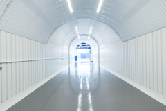 An empty arch with white lining and full height glazing to the front.