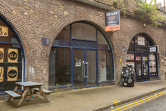 The front of an arch, with a fully glazed frontage and door allowing you to see into the arch interior.