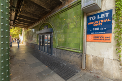 The front of an arch, with a fully glazed frontage and door allowing you to see into the arch interior.
