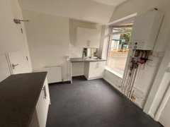 An empty arch with white lining and a WC cubicle to the front.