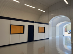 An empty arch with white lining and a WC cubicle to the front.