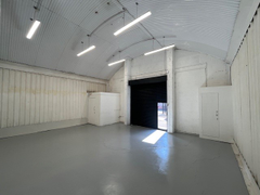 An empty arch with white lining and a WC cubicle to the front.
