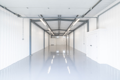 An empty arch with white lining and a WC cubicle to the back.