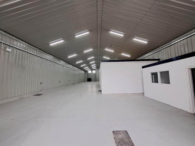 An empty arch with white lining and a WC cubicle to the front.