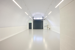 The front of an arch with an open electric roller shutter entrance big enough for vehicle access, and separate pedestrian door.