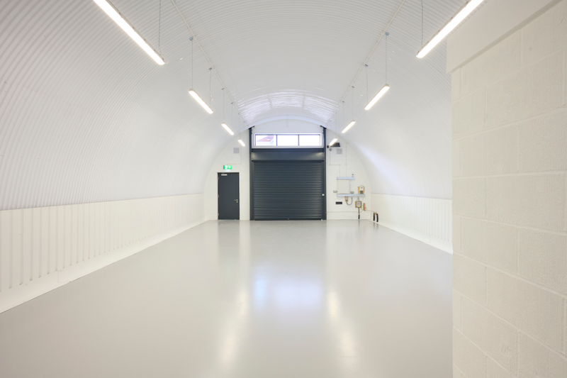 The front of an arch with an open electric roller shutter entrance big enough for vehicle access, and separate pedestrian door.