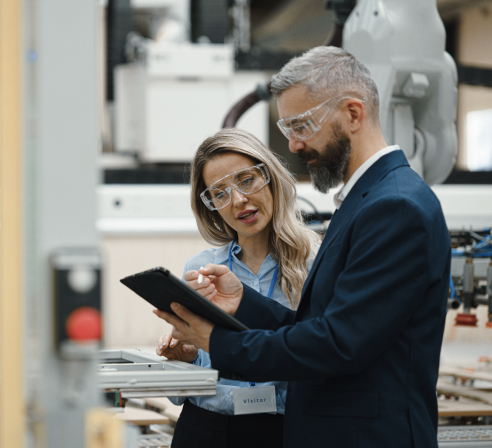 Man and woman looking at a tablet while discussing a time-sensitive shipment.