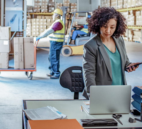 Employee working on a computer in a warehouse.