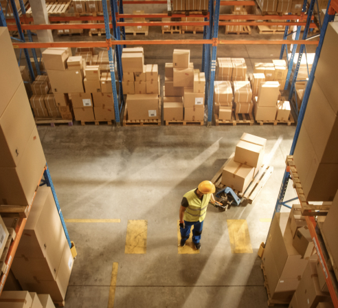 Aerial view of a man in a warehouse moving freight.