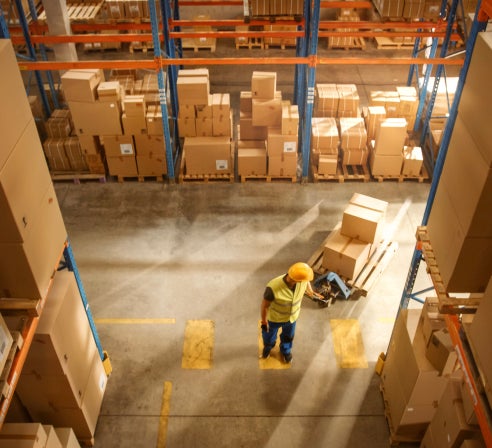 Aerial view of a man in a warehouse moving freight.