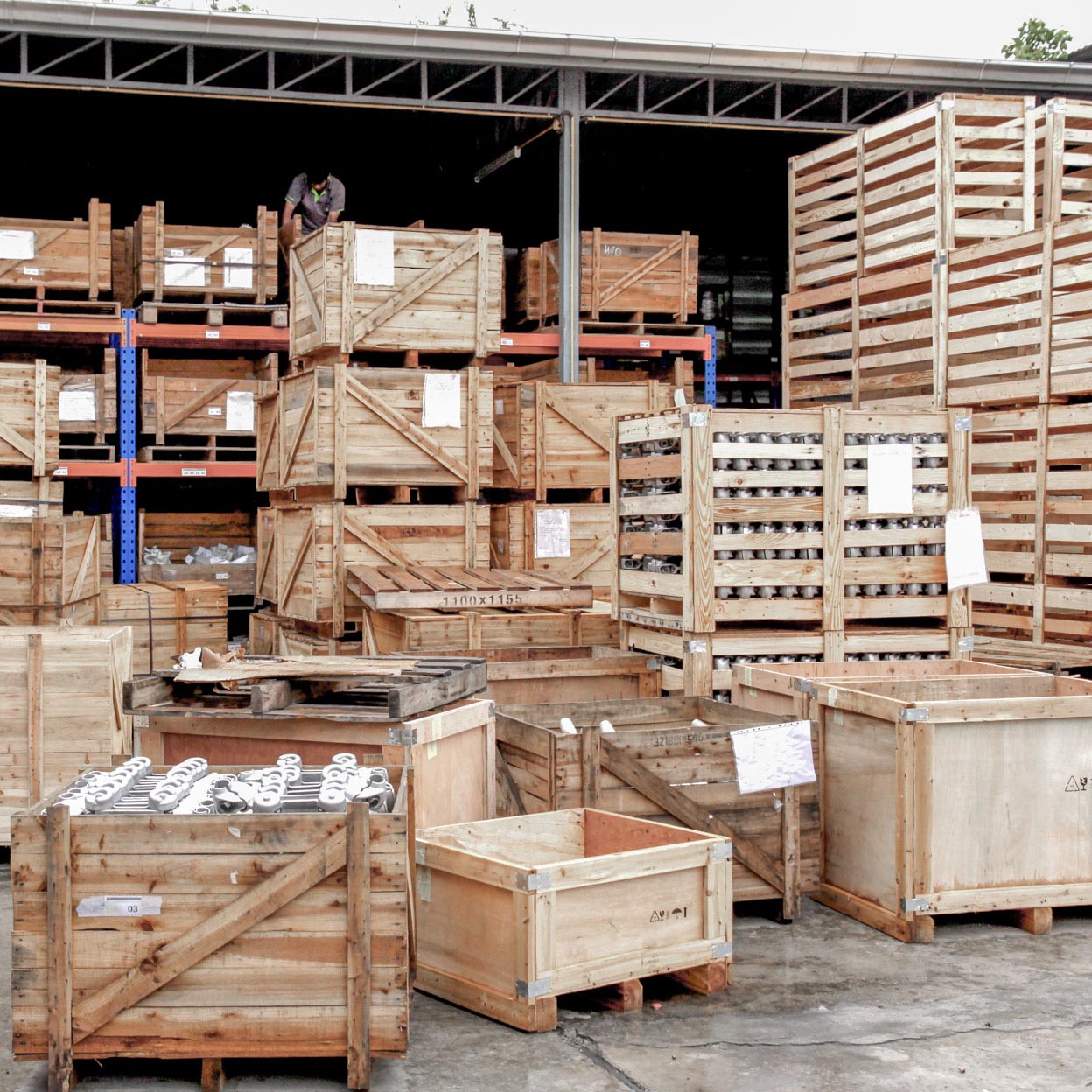 Stacked wooden shipping crates and pallets inside a warehouse.