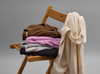 Vuori cashmere sweaters folded and hanging on a chair