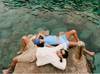 Vuori models lounging on a rock wearing versatile Vuori clothing and accessories