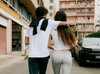 Vuori models wearing men's and women's white tees walking through a city street