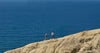 man and woman running up ocean bluff