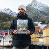 man holding lofoten harbor painting