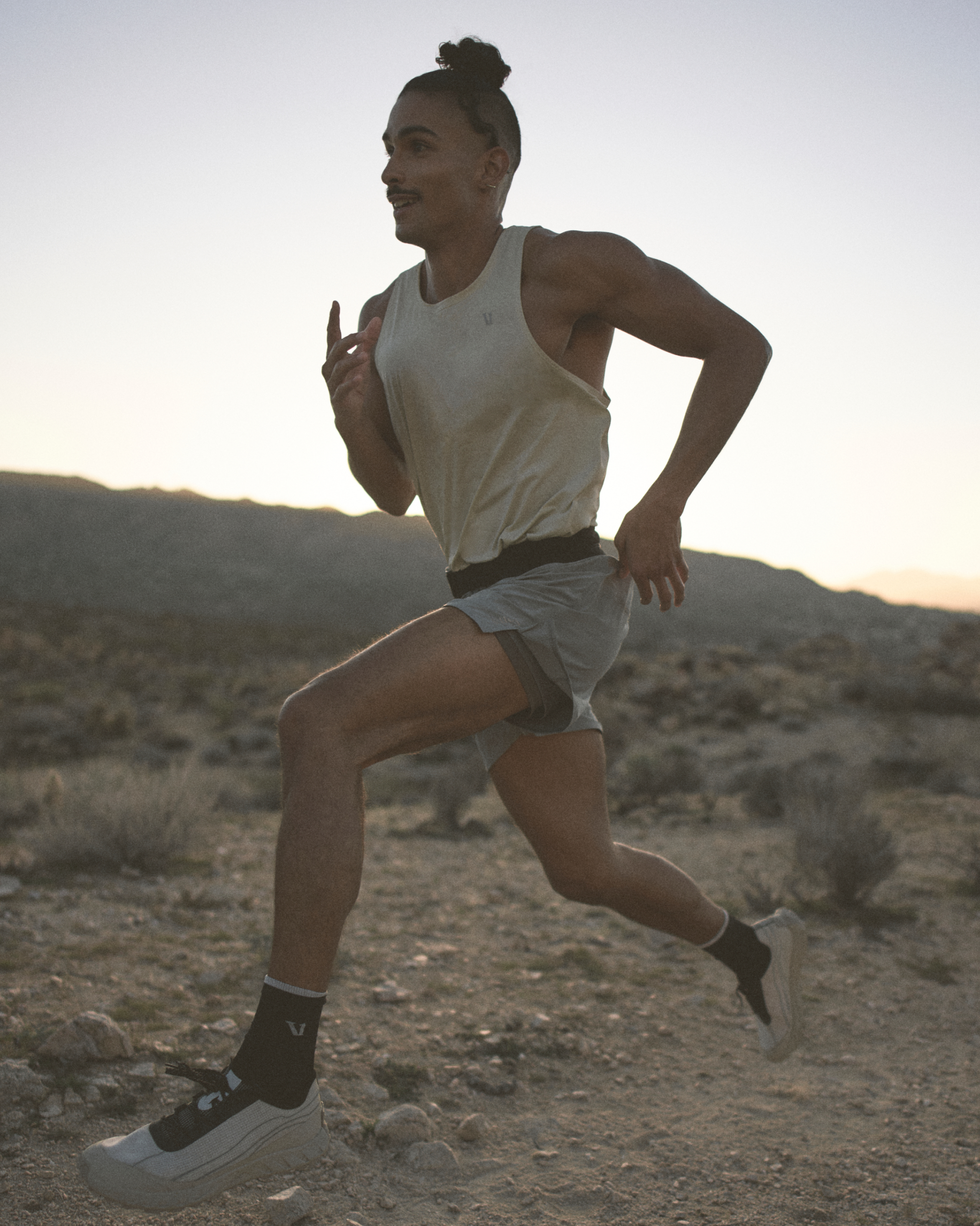 man wearing vuori running through the desert