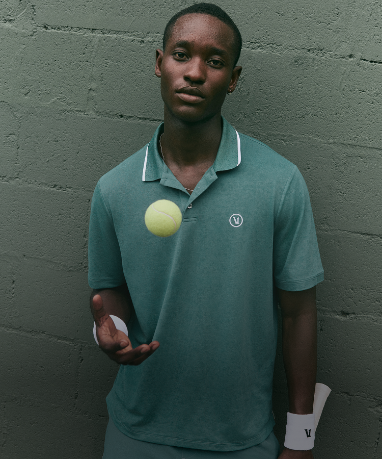 man wearing vuori clothing on tennis court