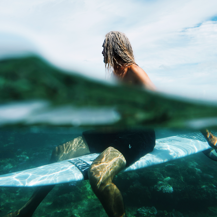 rob machado wearing vuori on surfboard