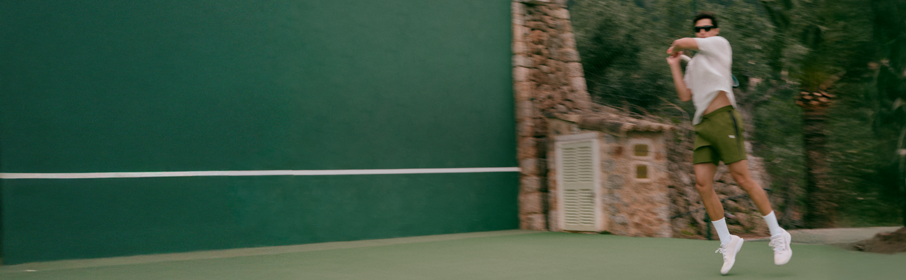 man wearing vuori clothing playing tennis