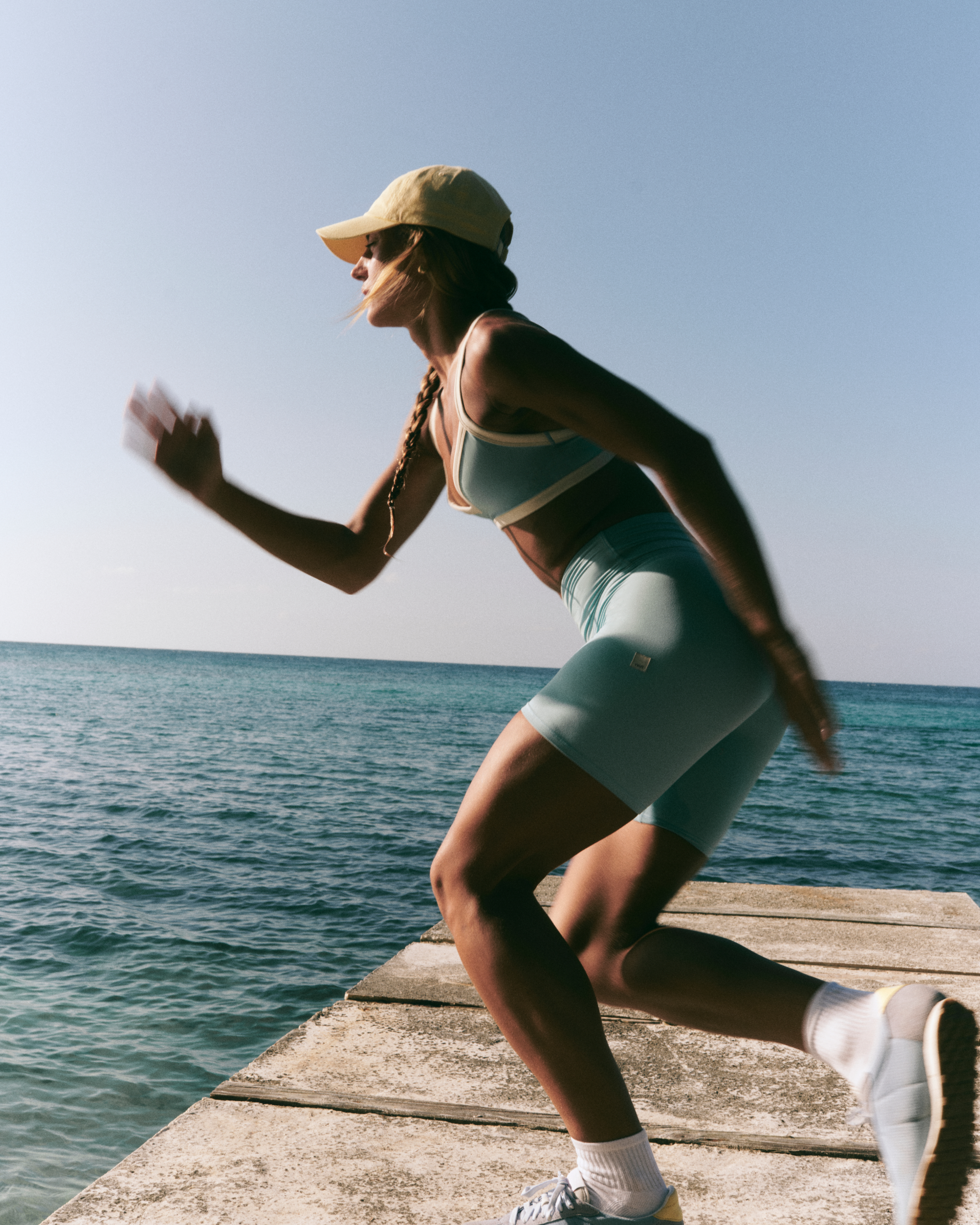 woman wearing vuori working out on a deck by the ocean