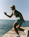 woman wearing vuori working out on a deck by the ocean
