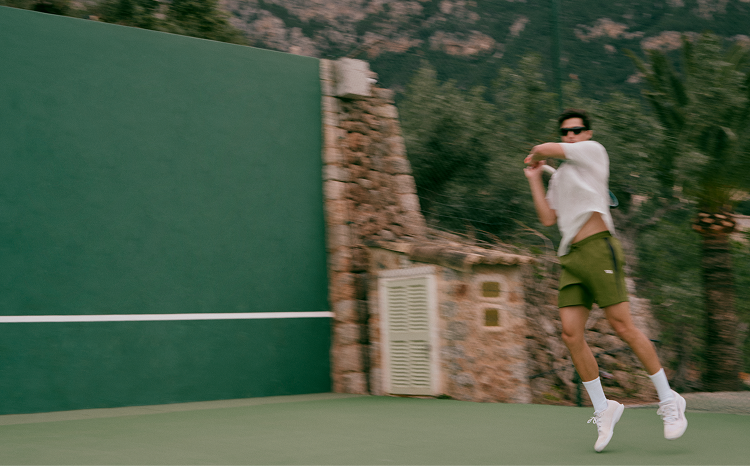 man wearing vuori clothing playing tennis
