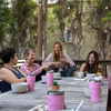 women eating together at a table with pink cups