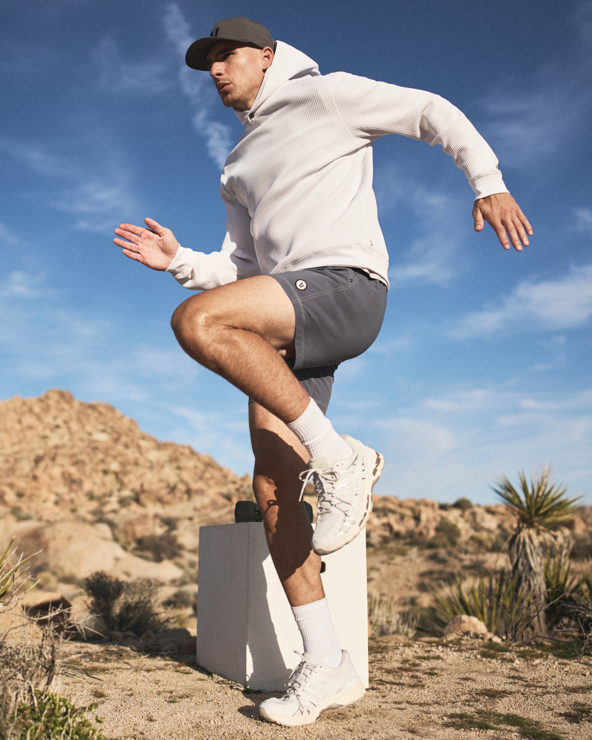 man wearing vuori doing high knees