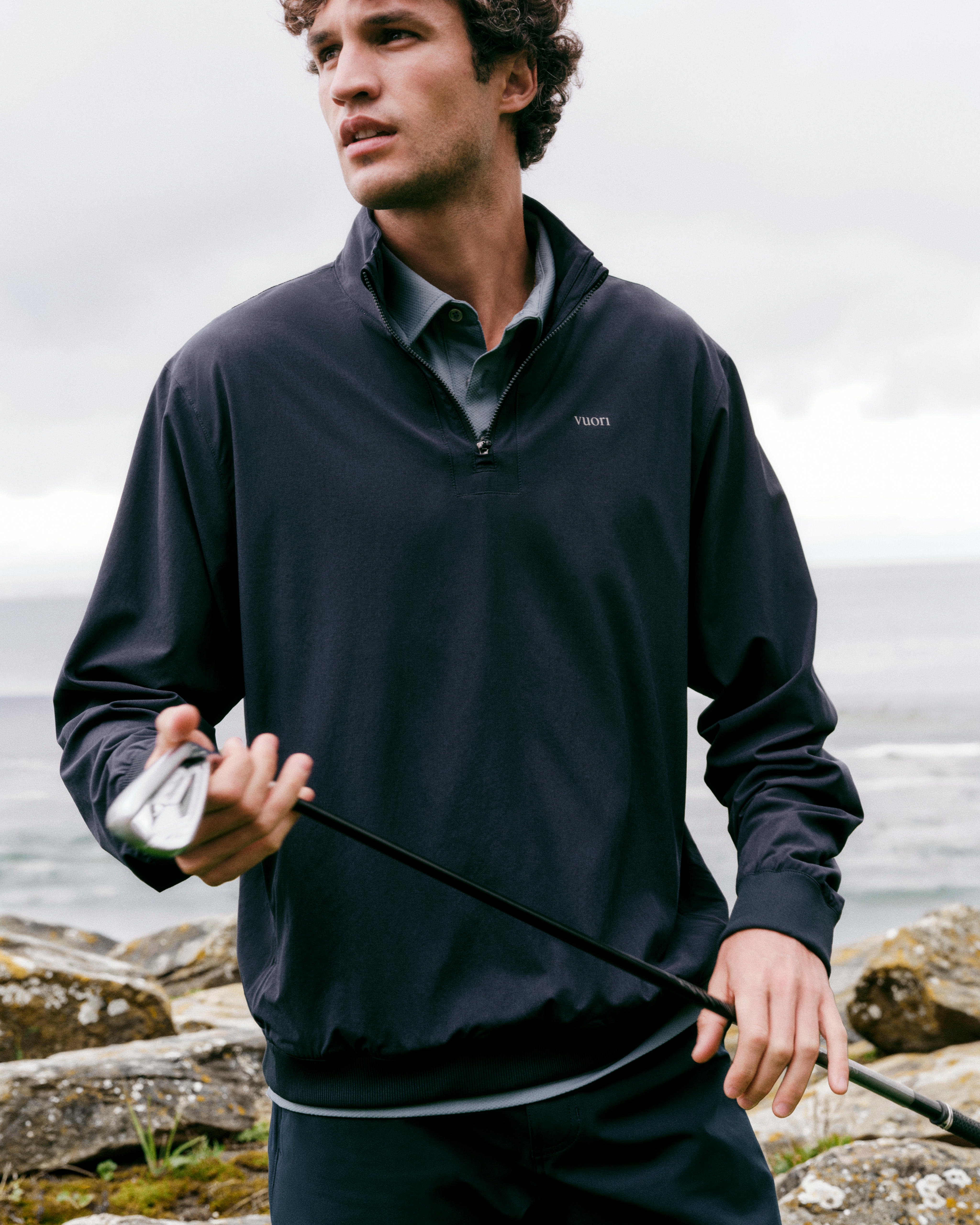 man with a golf club wearing vuori