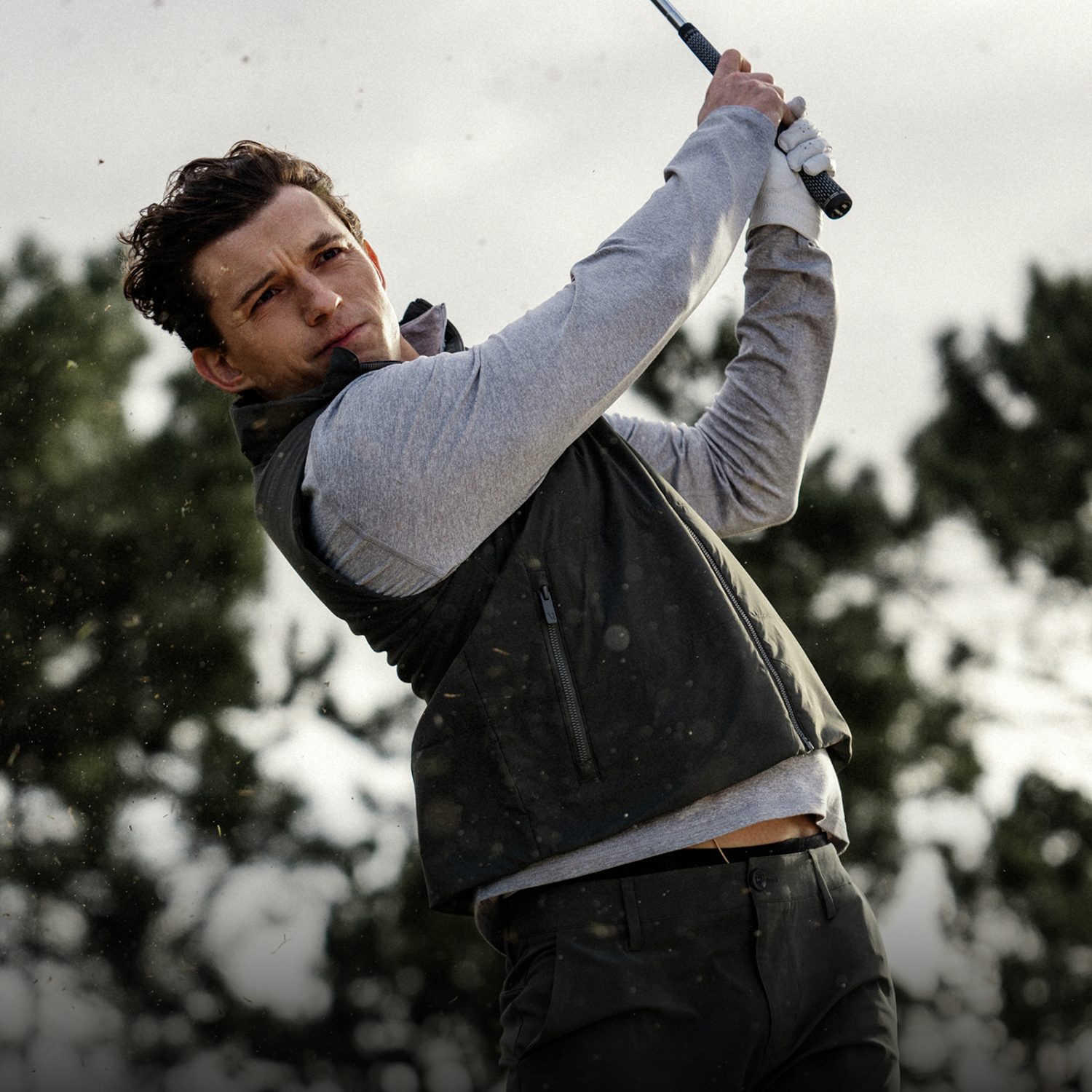 Tom Holland teeing off in the Vuori Aim Pant